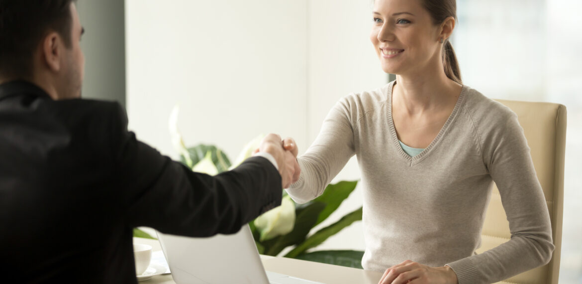 Female employee handshaking with male client